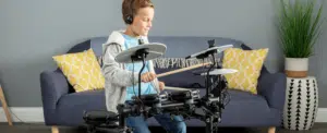 a boy playing a drum set Alesis Debut Kit leguidedesbatteurs.com