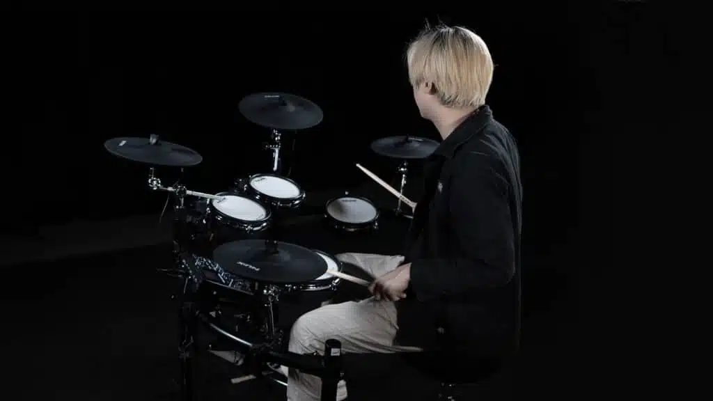 Jeune homme jouant de la batterie. Avis et test Nux DM7-X Mesh Kit leguidedesbatteurs.com