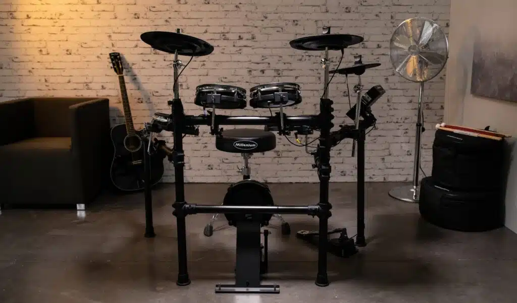 a drum set in a room with guitars Millenium MPS-450 leguidedesbatteurs.com