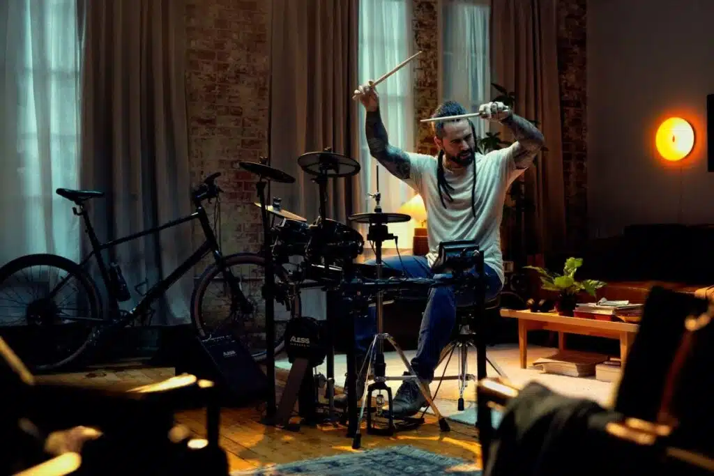 UN HOMME EN TRAIN DE JOUER DE LA BATTERIE ELECTRONIQUE. leguidedesbatteurs.com