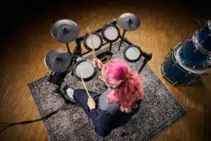 Femme avec cheveux roses jouant batterie Millenium MPS-350 leguidedesbatteurs.com