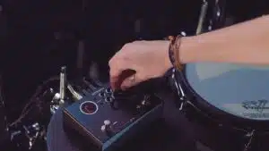 Un musicien ajuste un appareil électronique. Roland TM-1