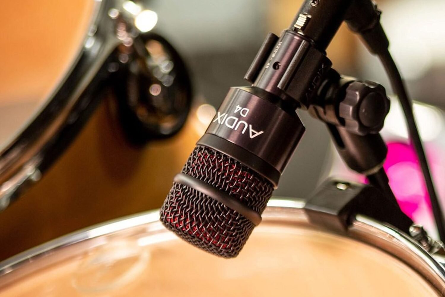 Micro Audix D4 du pack DP5-A fixé sur le cercle d'un tom, batterie en arrière-plan