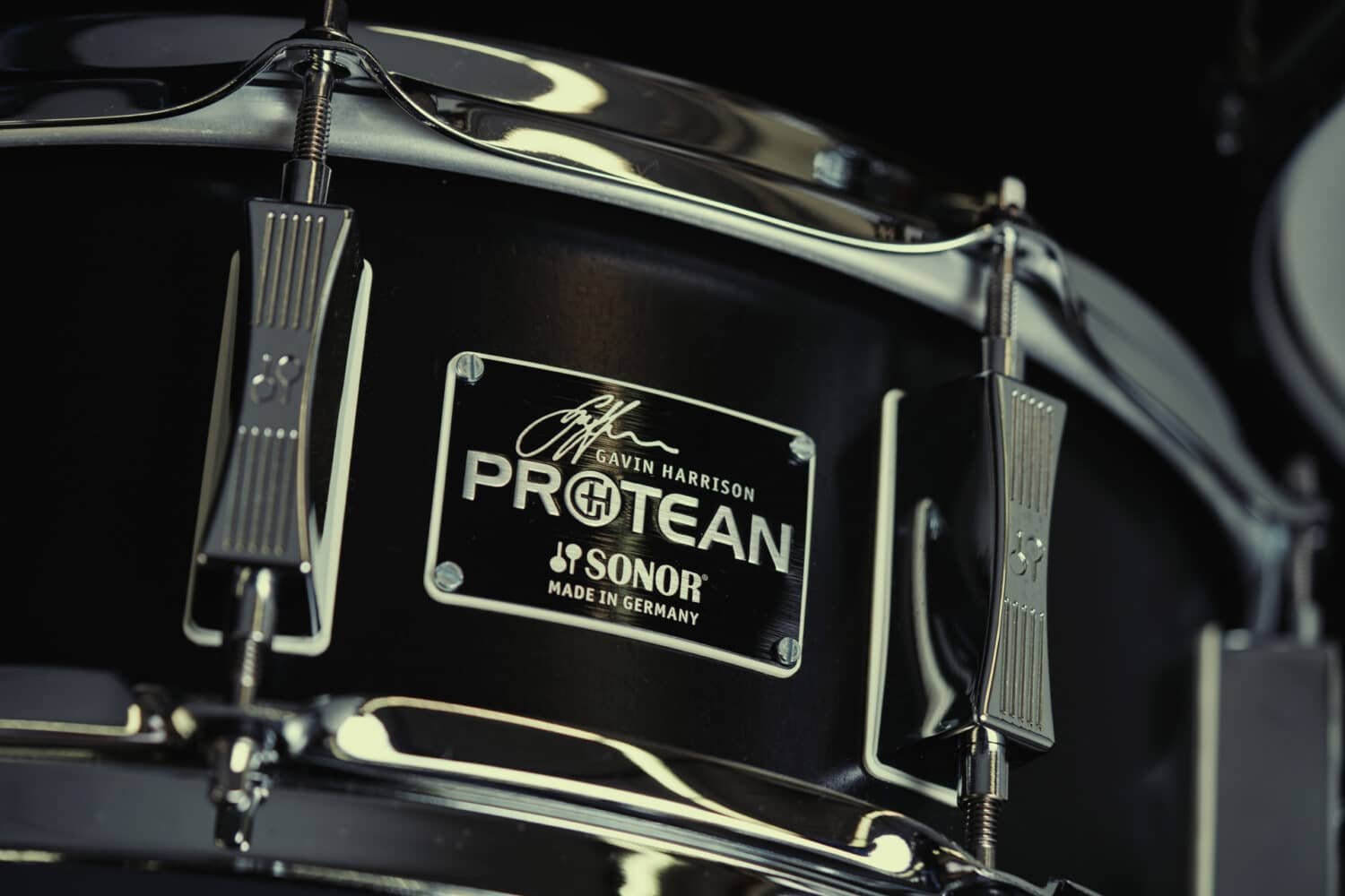 Caisse claire Sonor Protean Gavin Harrison montée devant une batterie, éclairage de scÚne sombre