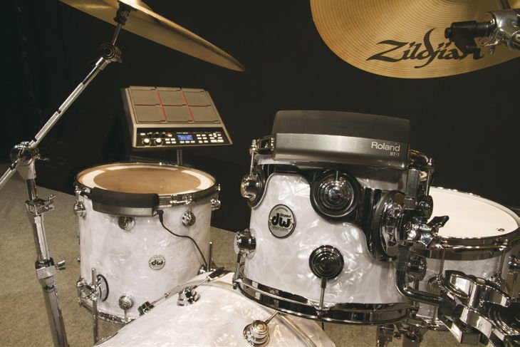 Roland BT-1 monté sur un tom acoustique blanc devant un pad de percussion Roland SPD-SX
