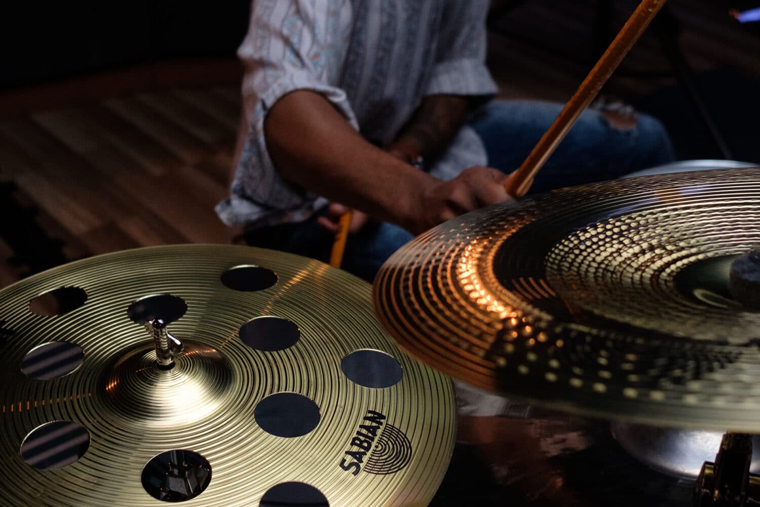Batteur frappant une cymbale Sabian SBR, gros plan sur les cymbales en laiton
