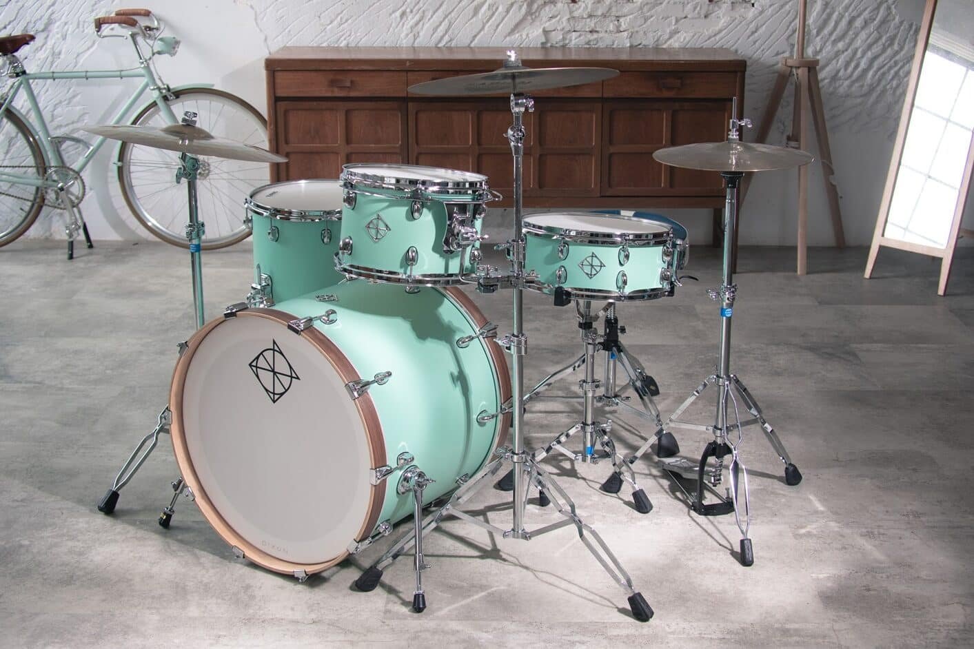 Batterie Dixon Cornerstone finition Neo-Mint installée dans un loft (vélo, buffet en bois)