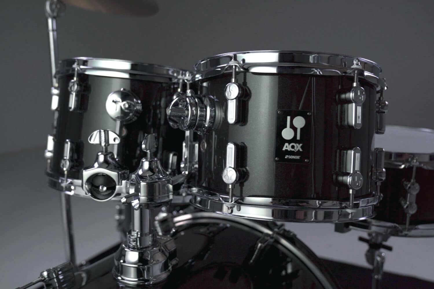 Toms d'une batterie Sonor AQX noire montée en studio, cymbale au-dessus